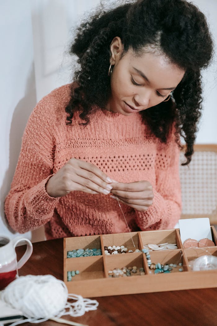 Crafting Captivating Headlines: Your awesome post title goes here Serious ethnic female stringing beads on thread while making decorative handmade feminine accessories in workshop